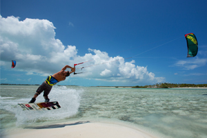 Kiteboarder Youri Zoon popping a jump over a tropical sandbar on his Best Kiteboarding gear.